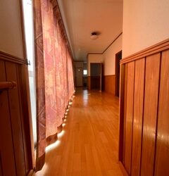 階段を上がった先は各部屋へと繋がる長い廊下。一面窓で開放感があります。突き当たりにはトイレと洗面スペースを配置。